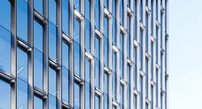 Blue glass office building facade against a clear sky