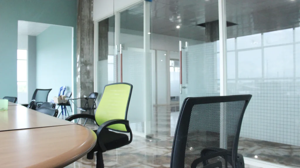 Meeting room with a table and chairs behind glass partitions