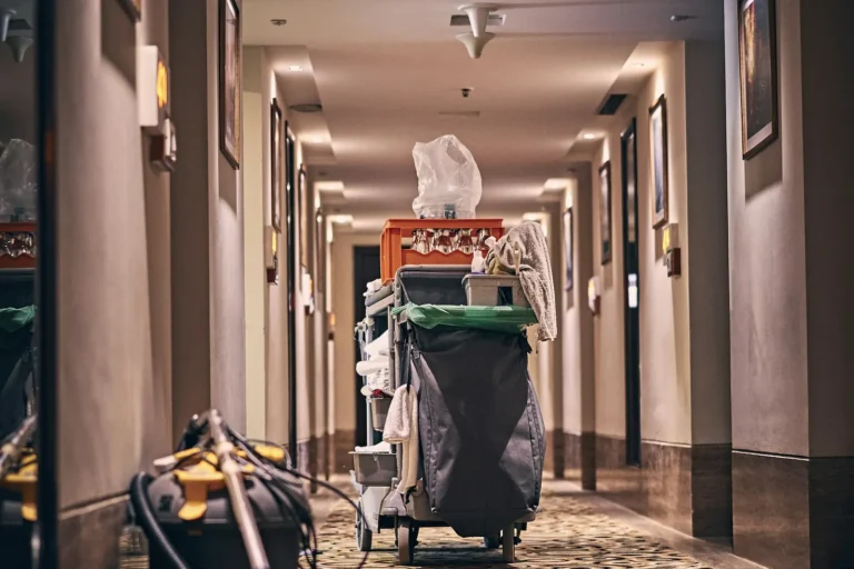Cleaning cart and vacuum in a carpeted building corridor